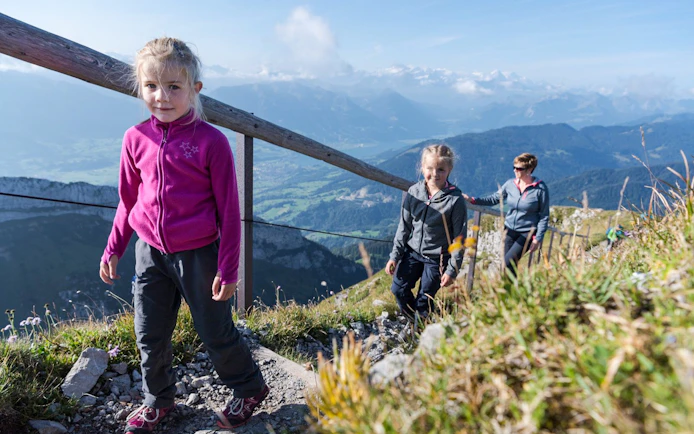 Family hiking on Mount Pilatus trail with scenic views, part of the Golden Round Trip from Lucerne.
