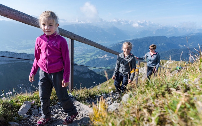 Family hiking on Mount Pilatus trail with scenic views, part of the Golden Round Trip from Lucerne.