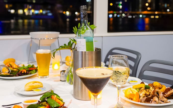 Dinner setting on a Gold Coast sightseeing cruise with wine, cocktails, and gourmet dishes.