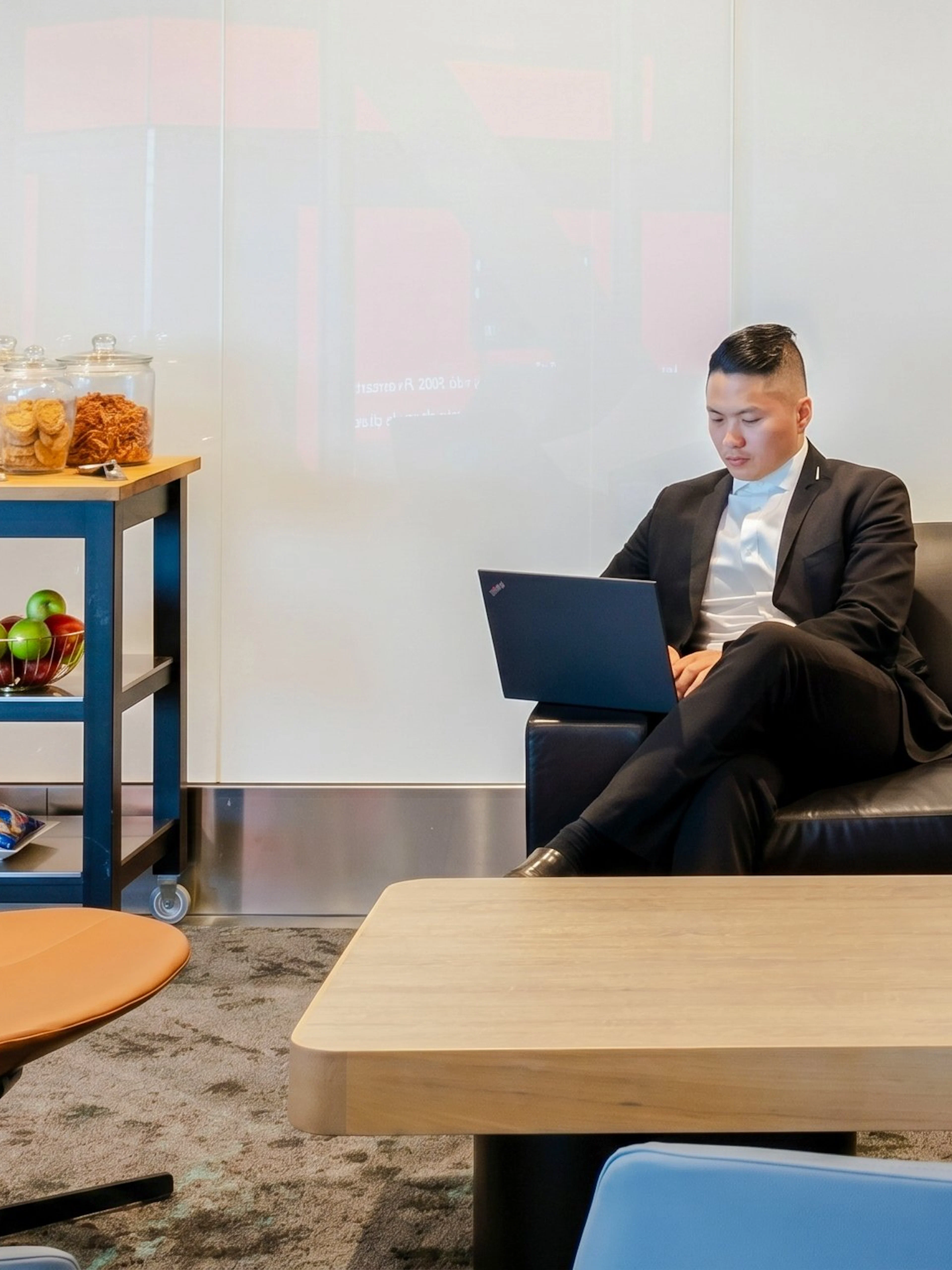 Person using laptop in Plaza Premium Lounge, Terminal 1, Toronto Pearson Airport.
