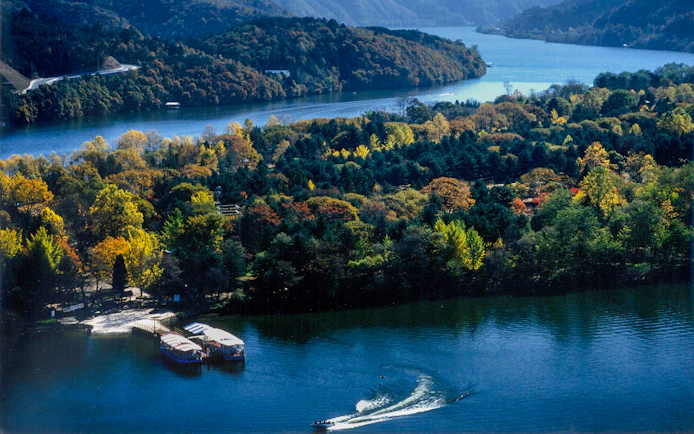 Scenic view of a waterbody and forested mountains in Nami Island, South Korea.