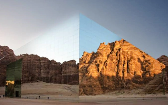Mirrored building reflecting desert cliffs in AlUla, Saudi Arabia, part of a private 2-day tour from Madinah.
