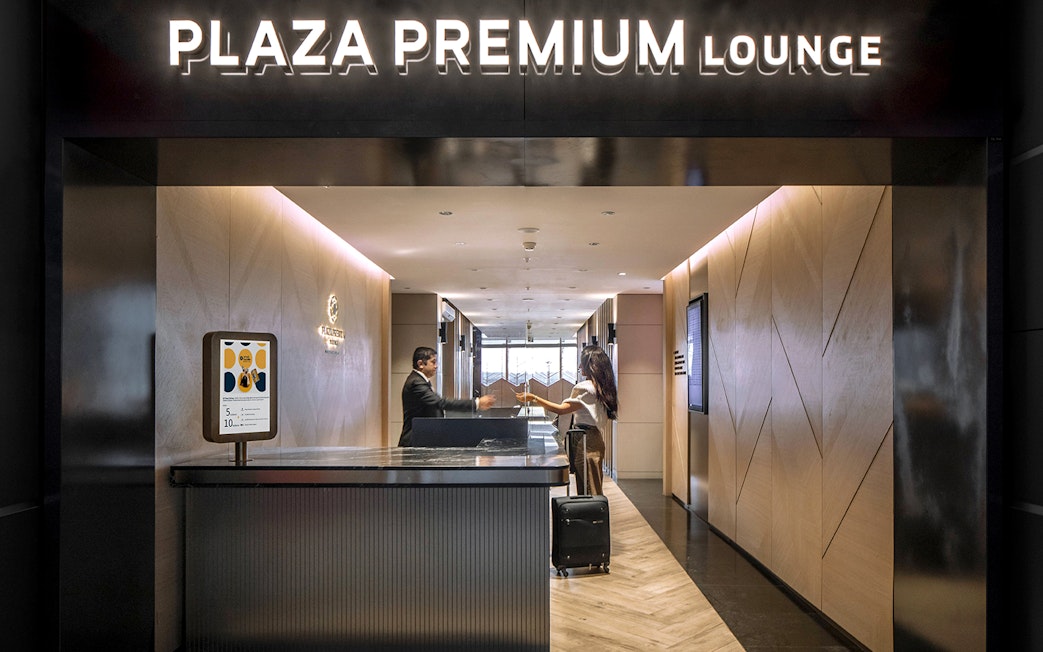 Plaza Premium Lounge entrance at Istanbul Ataturk Airport with reception desk.