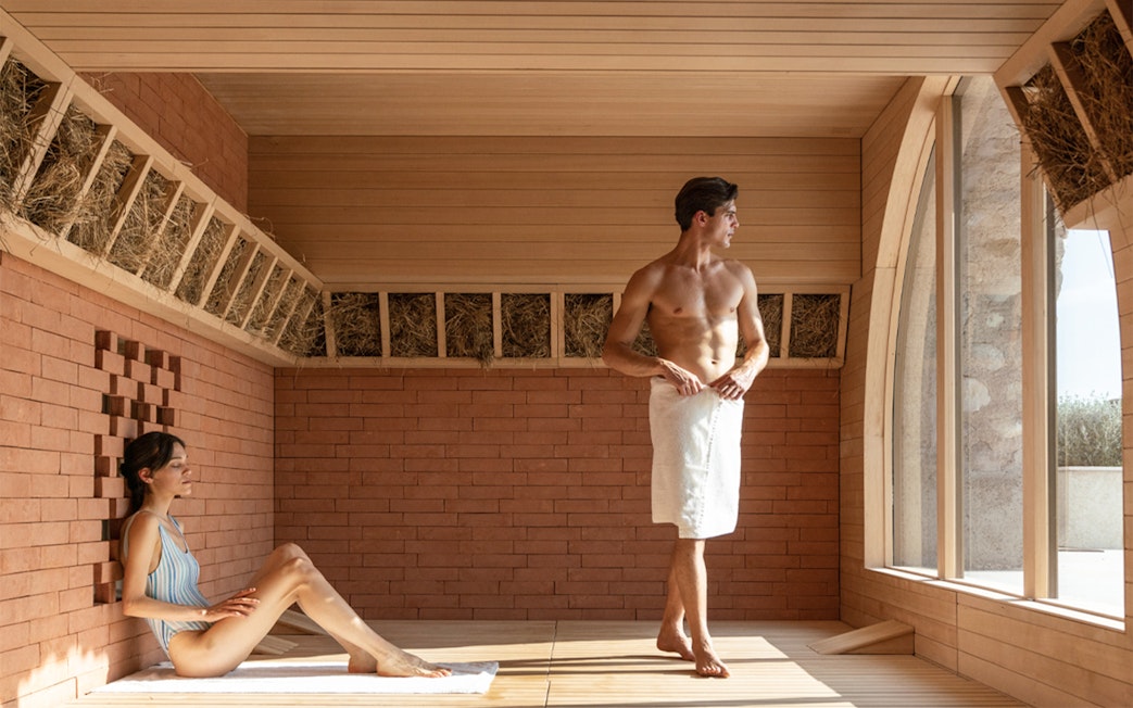 Two people relaxing in a sauna at QC Terme Garda.