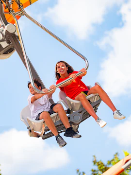 Children enjoying the Wind Star ride at Carowinds, Six Flags under a clear sky.