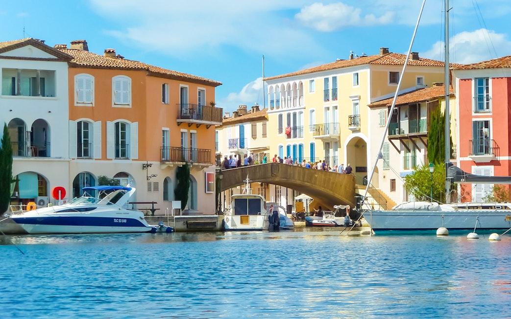 Port Grimaud canal with colorful buildings and boats, part of St Tropez day tour from Nice.