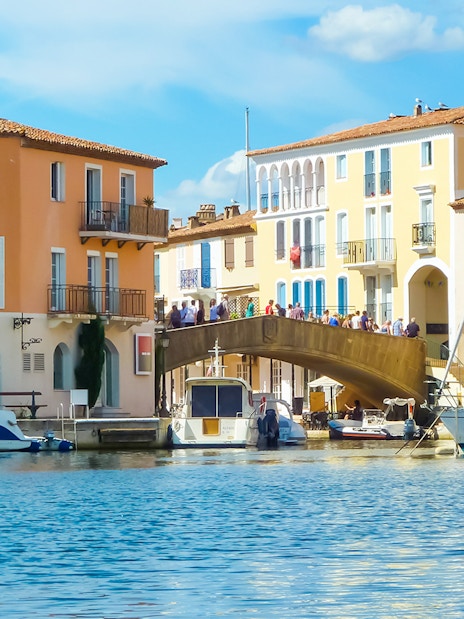 Port Grimaud canal with colorful buildings and boats, part of St Tropez day tour from Nice.