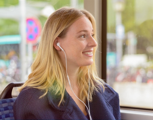 Frau genießt Audioguide auf der City Red Bus Tour in Bologna.