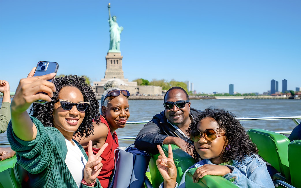 Guests enjoying NYC Speedboat Ride with Statue of Liberty in the background.
