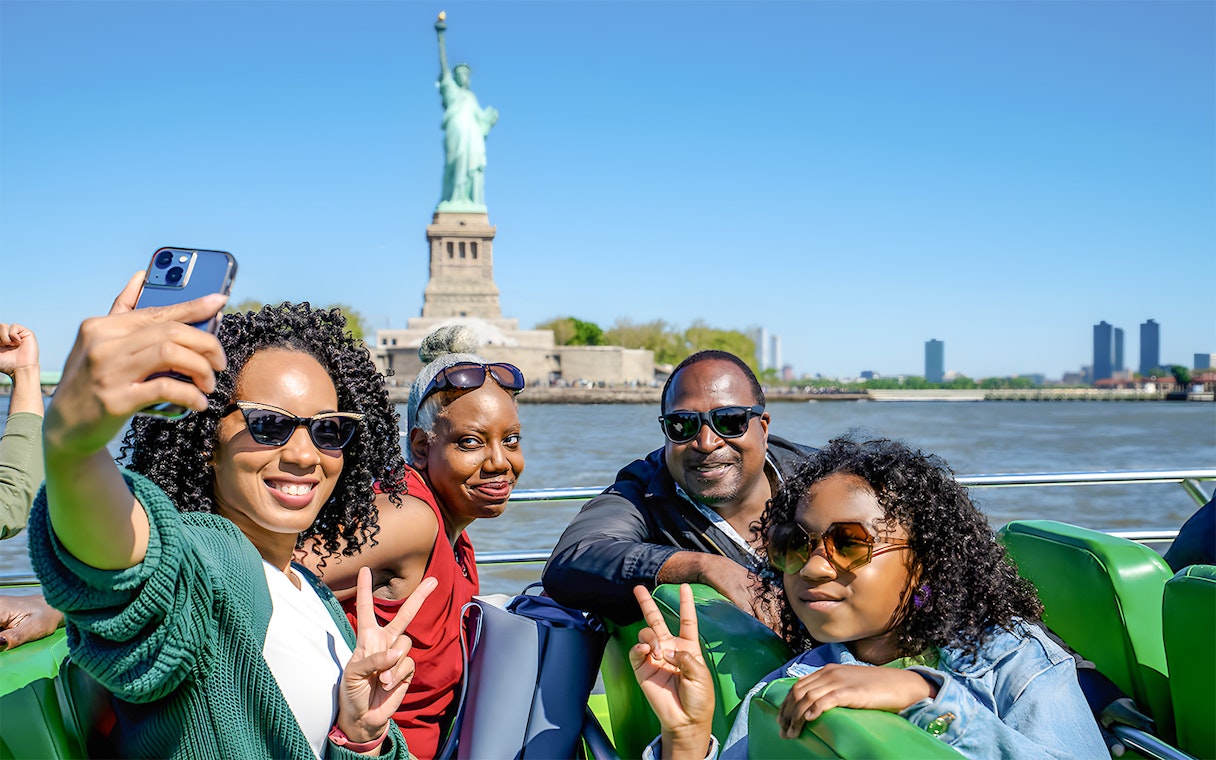 Guests enjoying NYC Speedboat Ride with Statue of Liberty in the background.