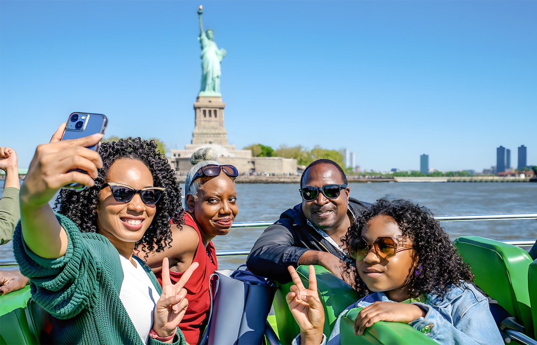 Guests enjoying NYC Speedboat Ride with Statue of Liberty in the background.
