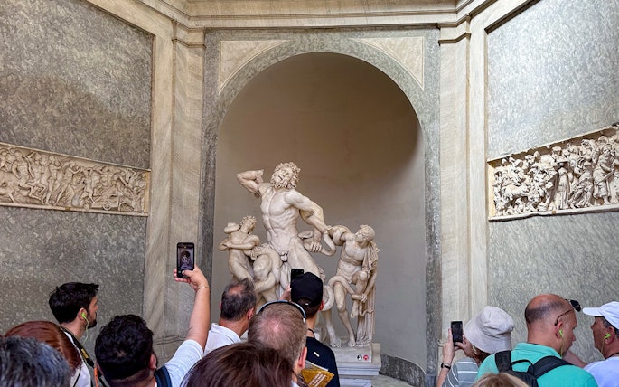 Tour group viewing Laocoön and His Sons statue in Vatican Museums.