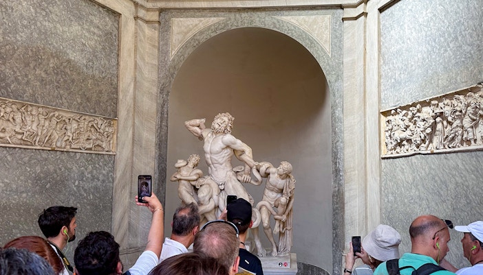 Tour group viewing Laocoön and His Sons statue in Vatican Museums.