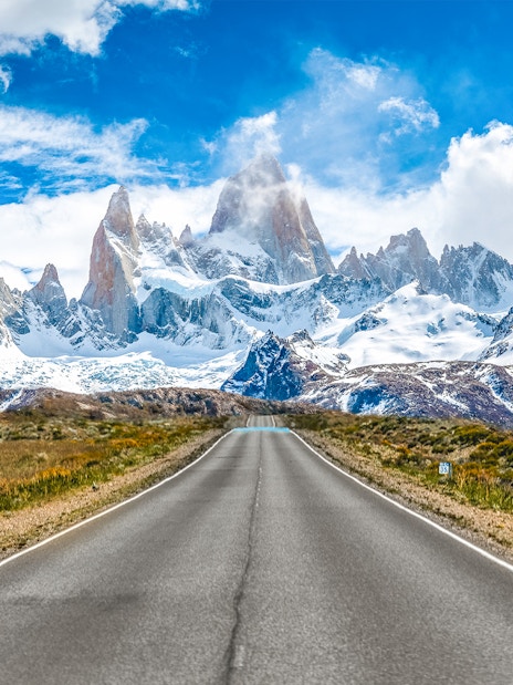 Road leading to Mount Fitz Roy in El Chaltén, Argentina, with snow-capped peaks in the background.