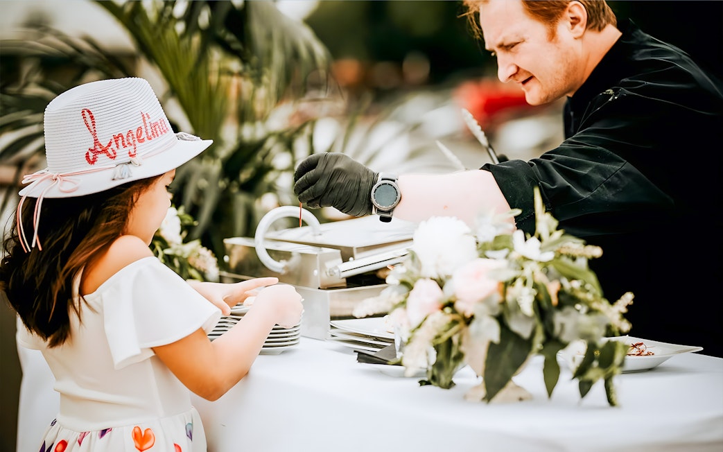 Chef serving food to a child on the Le Diamant Bleu Seine River cruise buffet.