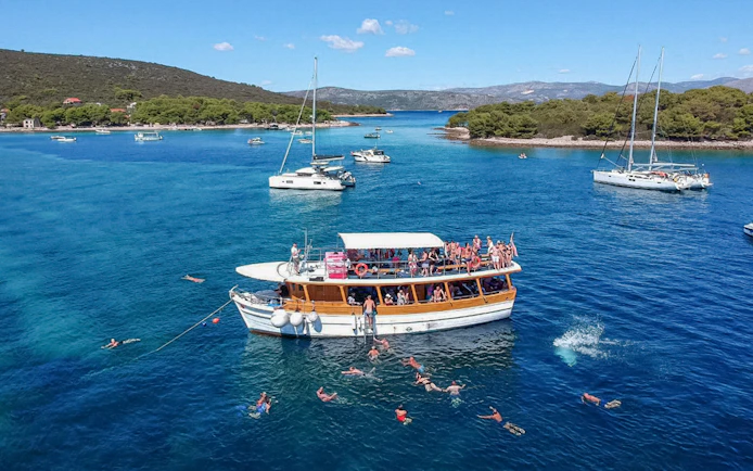 Cruise boat with swimmers near Elaphite Islands, Croatia.