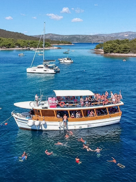 Cruise boat with swimmers near Elaphite Islands, Croatia.