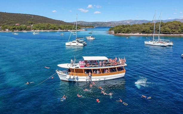 Cruise boat with swimmers near Elaphite Islands, Croatia.