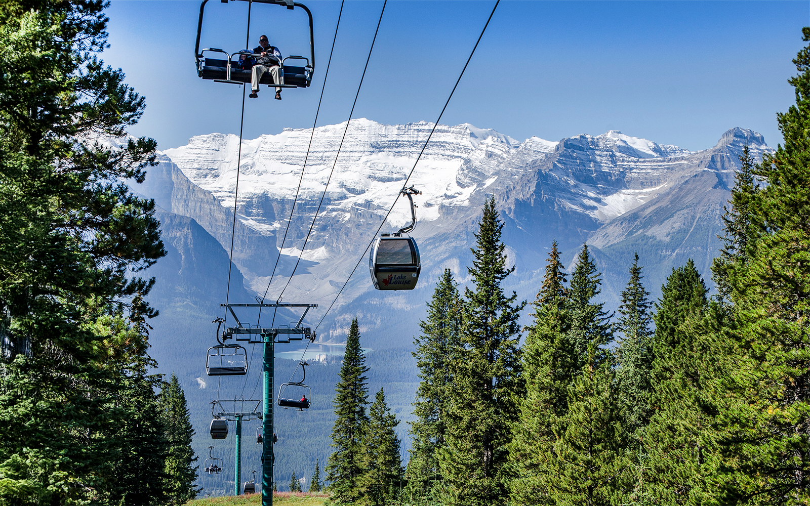 Banff Sightseeing Gondola over Sulphur Mountains with forest and snow-capped peaks in Banff National Park.