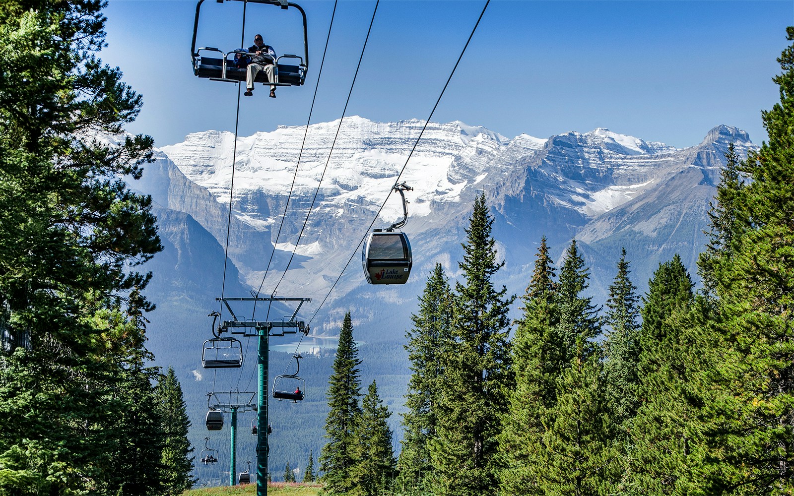 Banff Sightseeing Gondola over Sulphur Mountains with forest and snow-capped peaks in Banff National Park.