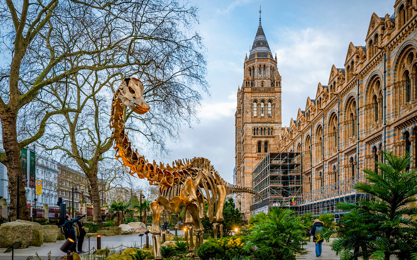 Dinosaur sculpture outside Natural History Museum, London, with historic architecture in the background.