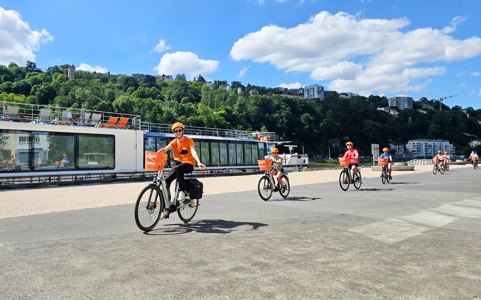 Cyclists on a guided bike tour along the river in Lyon, France.