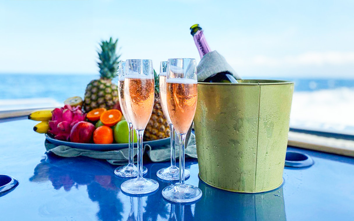 Champagne glasses and tropical fruit on a boat near Nusa Penida.