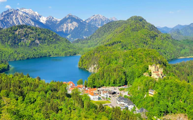 Neuschwanstein and Hohenschwangau Castles surrounded by Bavarian Alps and lake.