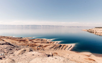Dead Sea shoreline with salt formations, part of Amman: Petra, Wadi Rum, and Dead Sea 2-Day Tour.