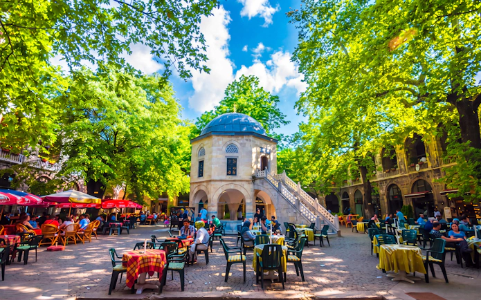 Courtyard of Koza Han in Bursa with outdoor seating and historic architecture.