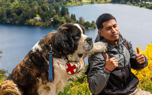Traveler with St. Bernard dog in Bariloche mountain region, Argentina.