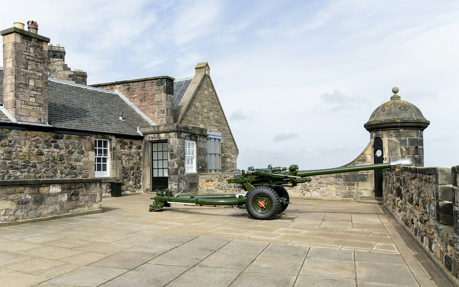Canon gun on Edinburgh Castle terrace with stone buildings in the background.