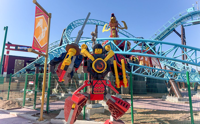 Lego samurai statue in front of roller coaster at Legoland.