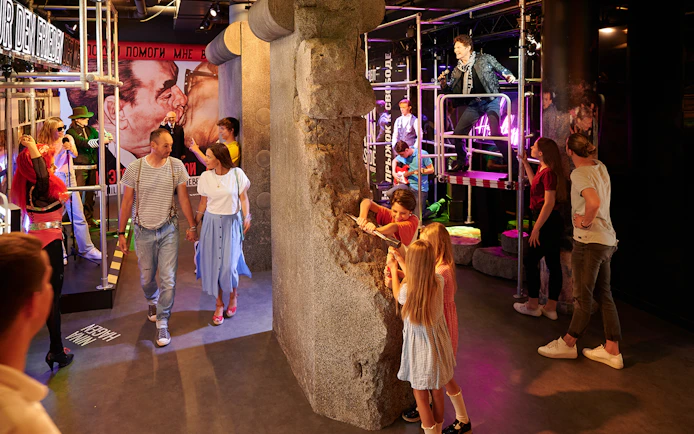 Visitors exploring Madame Tussauds Berlin with interactive Berlin Wall exhibit.