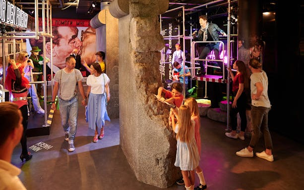 Visitors exploring Madame Tussauds Berlin with interactive Berlin Wall exhibit.