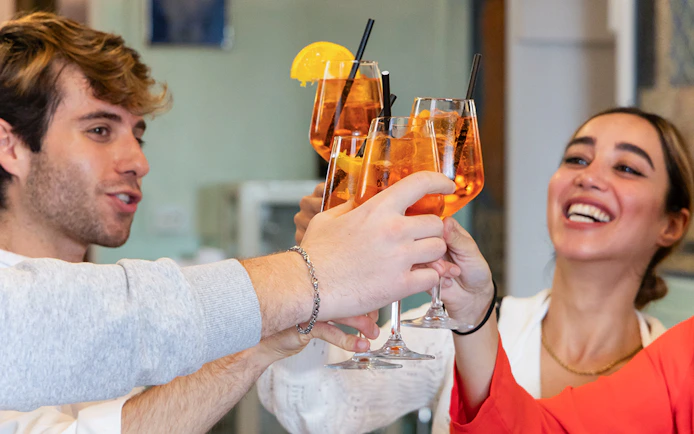 People toasting with Aperol Spritz at a Rome cooking class.