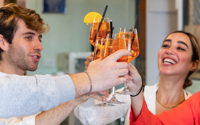 People toasting with Aperol Spritz at a Rome cooking class.