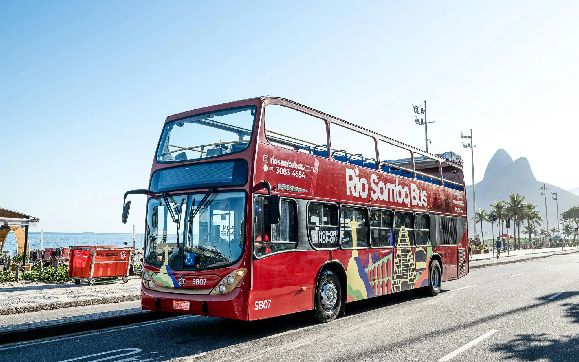 Rio Samba Bus on a sunny street in Rio de Janeiro with mountains in the background.