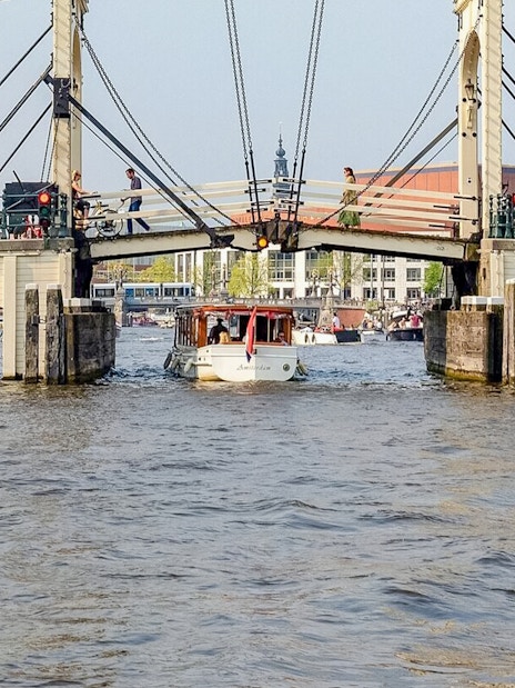 Boat passing under Amsterdam's Magere Brug on a canal cruise.