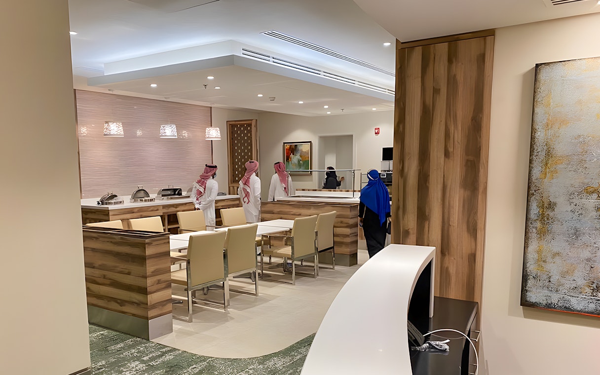 Premium lounge interior at Jeddah Airport with seating and buffet area.
