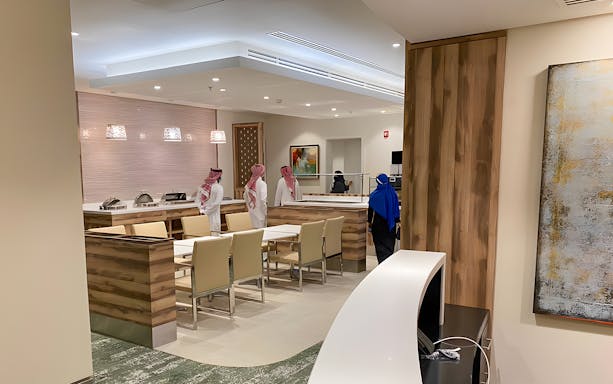 Premium lounge interior at Jeddah Airport with seating and buffet area.