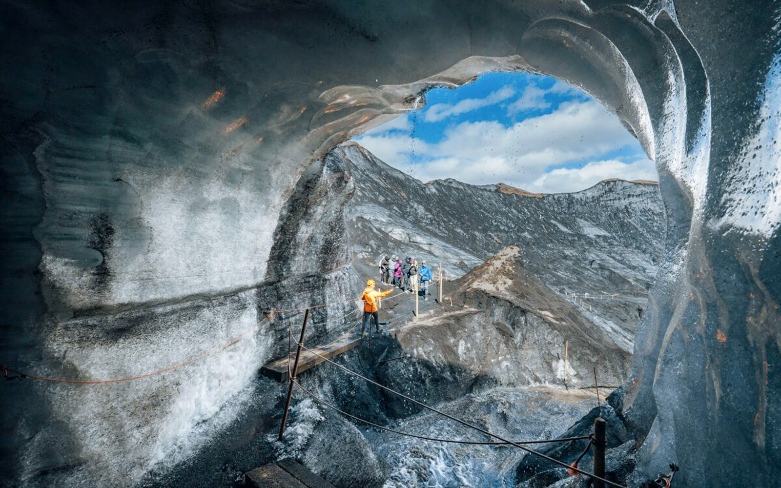 Guests exploring inside Katla Ice Cave in Iceland with guide.