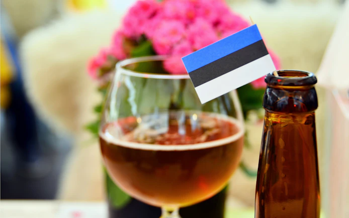 Tallinn beer with Estonian flag in glass and bottle nearby.