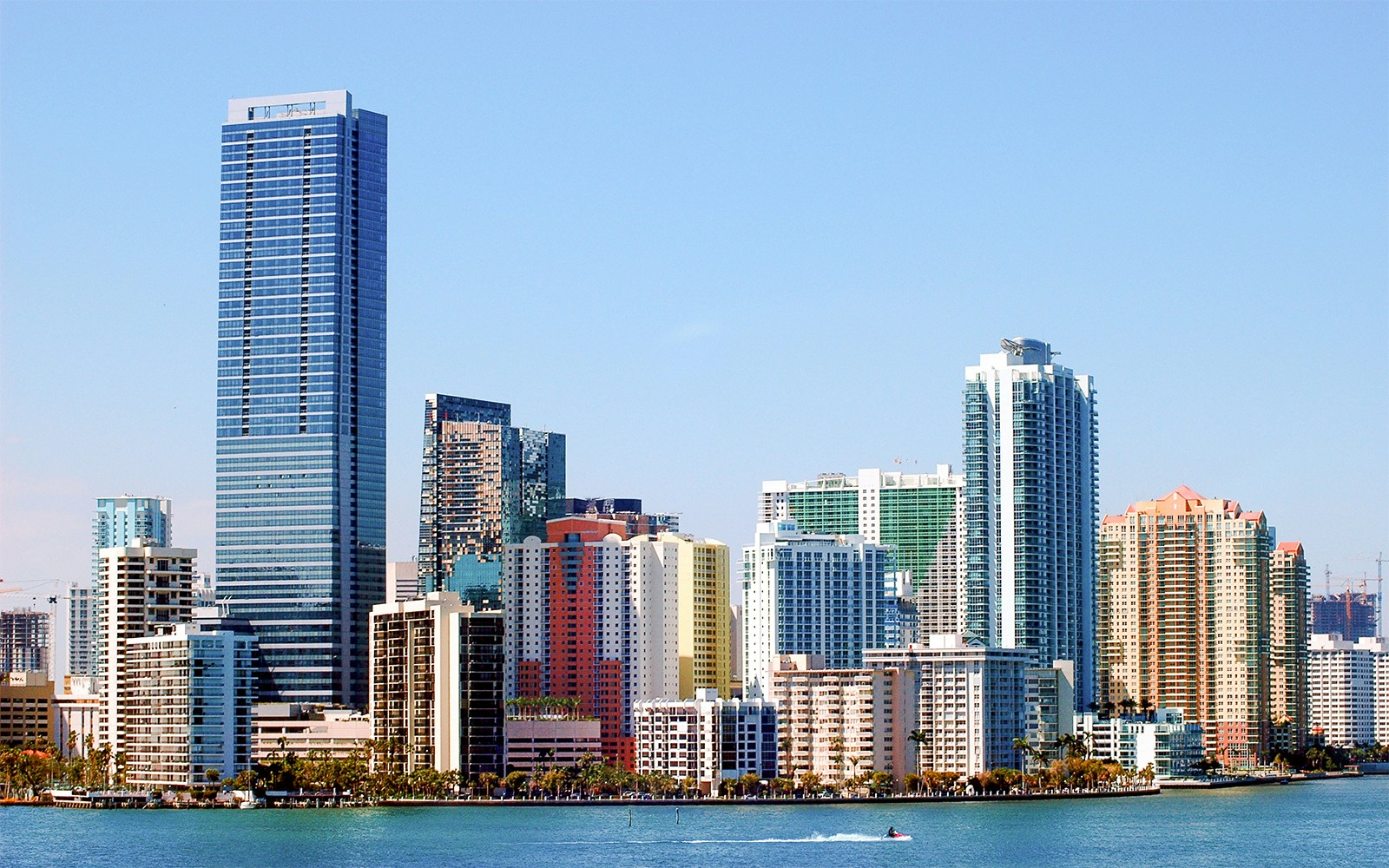 Miami skyline view from Biscayne Bay with high-rise buildings and clear blue sky.