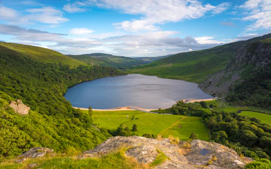 Lough Tay lake surrounded by lush greenery in Wicklow Mountains, Ireland.