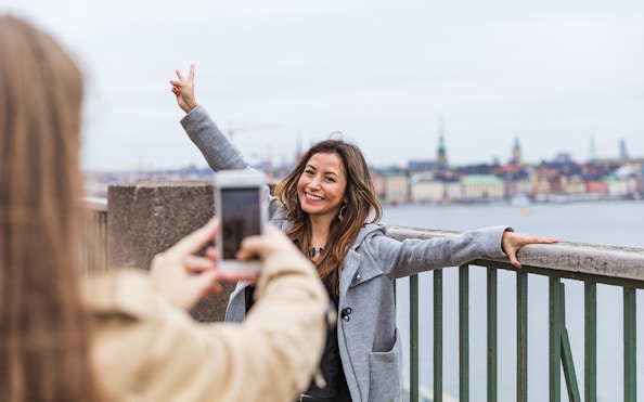 Person posing for a photo with Stockholm skyline in the background.