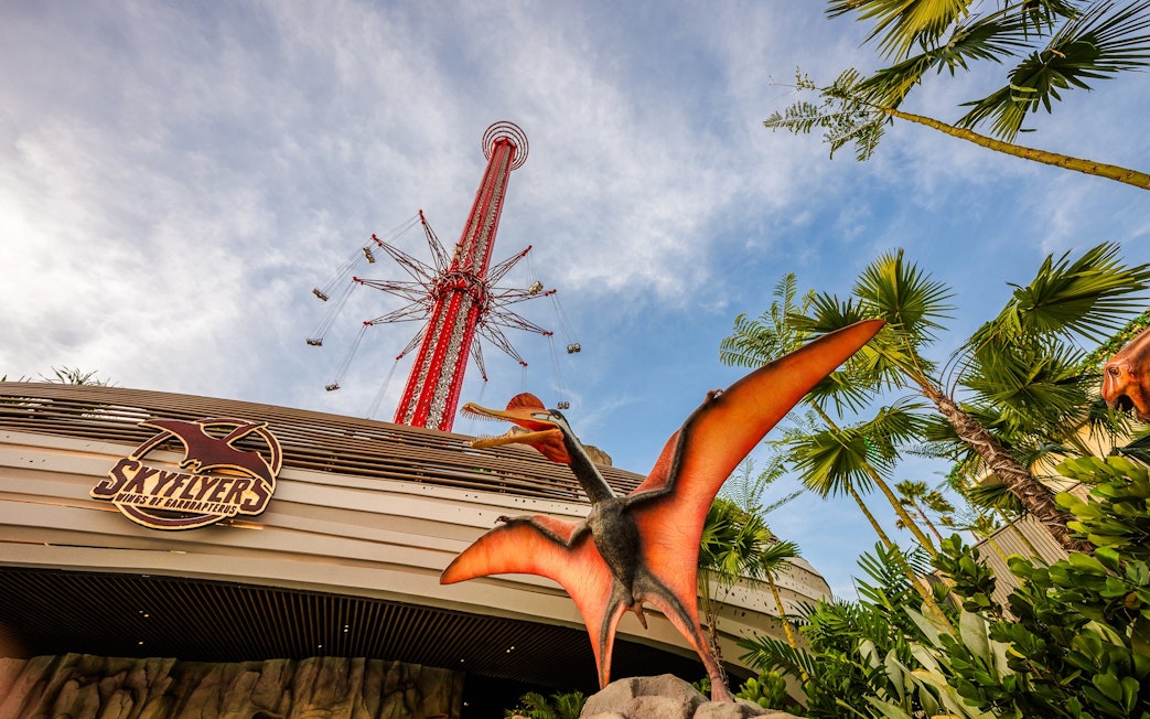 SkyFlyers ride exterior with dinosaur statue at Asiatique Bangkok.