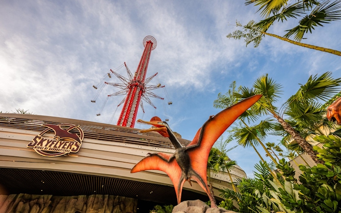 SkyFlyers ride exterior with dinosaur statue at Asiatique Bangkok.