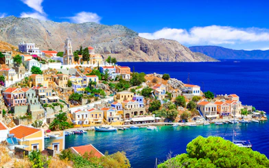 Panoramic view of colorful houses and boats in Symi harbor, Rhodes.