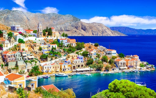 Panoramic view of colorful houses and boats in Symi harbor, Rhodes.